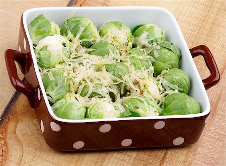 simsearch:400-07625359,k - Delicious Brussels Sprouts Casserole with Grated Cheese and Spices in Brown Polka Dot Bowl closeup on Wooden background Photographie de stock - Aubaine LD & Abonnement, Code: 400-07297340