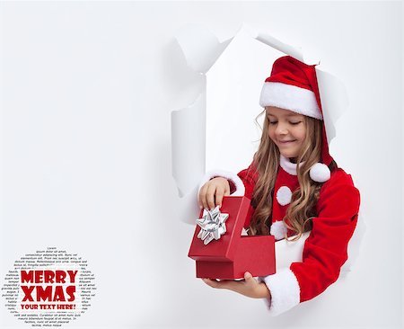 Little girl opening christmas present - with lots of copy space Stock Photo - Budget Royalty-Free & Subscription, Code: 400-07297823