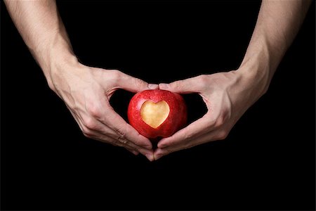 adult man hands holding apple with carved heart, isolated on black Stock Photo - Budget Royalty-Free & Subscription, Code: 400-07298813