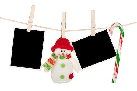 film on strings with clothing pin - Blank photo frames and snowman hanging on the clothesline. Isolated on white background Stock Photo - Budget Royalty-Free & Subscription, Code: 400-07299402