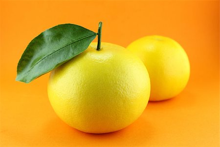 Ripe appetizing grapefruit with leaf on orange background. Stock Photo - Budget Royalty-Free & Subscription, Code: 400-07290441