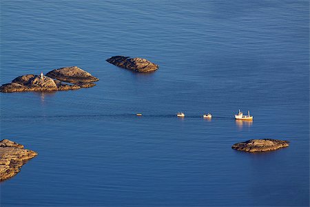 Bird eye view of fishing boats sailing between by rocky islets near Henningsvaer on Lofoten islands in Norway Fotografie stock - Microstock e Abbonamento, Codice: 400-07292959