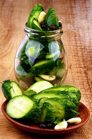 pickling gherkin - Arrangement of Sliced Delicious Pickled Cucumbers in Brown Plate and Glass Jar closeup on Wooden background Stock Photo - Budget Royalty-Free & Subscription, Code: 400-07293268