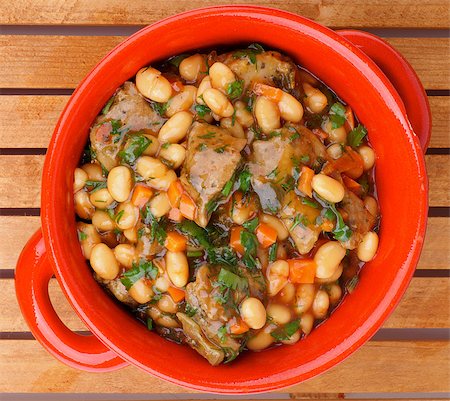 simsearch:400-04907477,k - Delicious Homemade White Beans Stew with Beef and Greens in Red Pot closeup on Wooden background. Top View Stockbilder - Microstock & Abonnement, Bildnummer: 400-07293676