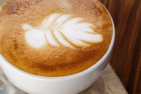 simsearch:400-07306295,k - freshly made cup of cappuccino with leaf art, on wooden table Stock Photo - Budget Royalty-Free & Subscription, Code: 400-07304077