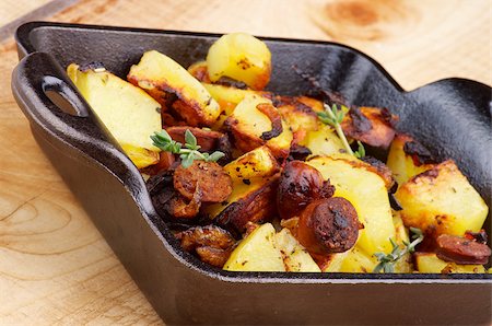 simsearch:400-07410171,k - Tasty Homemade Roasted Sausages and Potato Stew in Black Frying Pan closeup on Wooden background Stockbilder - Microstock & Abonnement, Bildnummer: 400-07304675