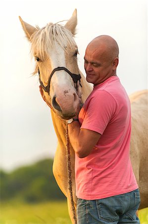 Photo bald man walks with a horse in the field Stock Photo - Budget Royalty-Free & Subscription, Code: 400-07304701