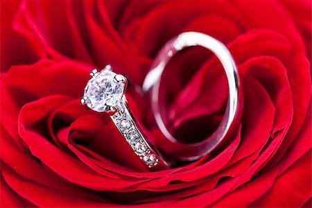 petal on stone - Overhead view of a diamond engagement ring nestling in the heart of a red rose amongst the soft petals Stock Photo - Budget Royalty-Free & Subscription, Code: 400-07305091