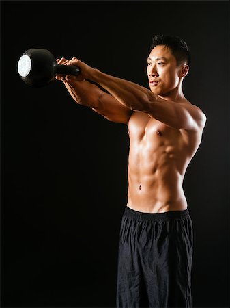 simsearch:400-06208099,k - Photo of an Asian male exercising with a kettle bell over dark background. Photographie de stock - Aubaine LD & Abonnement, Code: 400-07305581