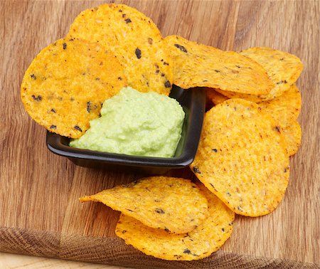 simsearch:400-06689258,k - Arrangement of Tortilla Chips and Guacamole Sauce in Black Bowl closeup on Wooden Board Stock Photo - Budget Royalty-Free & Subscription, Code: 400-07305903