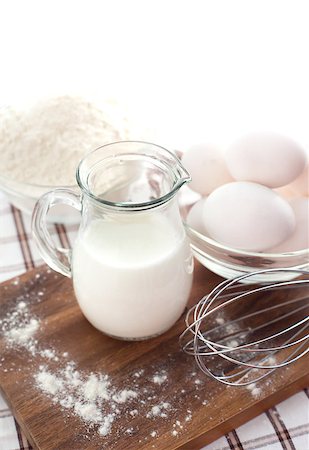 Baking ingredients with milk, eggs, whisk and flour on the table Stockbilder - Microstock & Abonnement, Bildnummer: 400-07306555