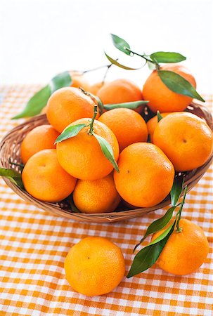 fruit winter basket - Fresh tangerines with leaves in a  basket on the table Photographie de stock - Aubaine LD & Abonnement, Code: 400-07306558