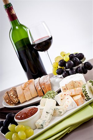 different cheese types on plate with grapes and red wine on wooden table Stock Photo - Budget Royalty-Free & Subscription, Code: 400-07307126