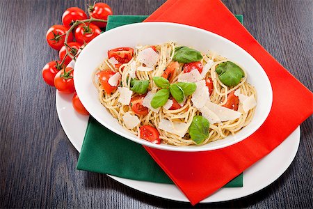 simsearch:400-04341378,k - fresh tasty pasta spaghetti with tomatoes parmesan and basil on table Fotografie stock - Microstock e Abbonamento, Codice: 400-07307159