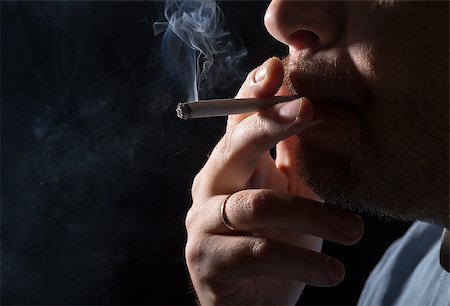 smoker - Portrait man smoking cigarette, closeup on black background Foto de stock - Super Valor sin royalties y Suscripción, Código: 400-07308338