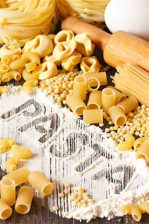 simsearch:400-08776897,k - Assortment of dry pasta on a kitchen table with flour and rolling pin. Stockbilder - Microstock & Abonnement, Bildnummer: 400-07300158