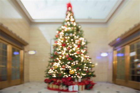 simsearch:400-07218254,k - Christmas Tree Decorated with Ornaments Poinsettia Sparkling Lights Snowflakes with Wrapped Gifts Under the Tree Blurred Bokeh Background Stock Photo - Budget Royalty-Free & Subscription, Code: 400-07300195