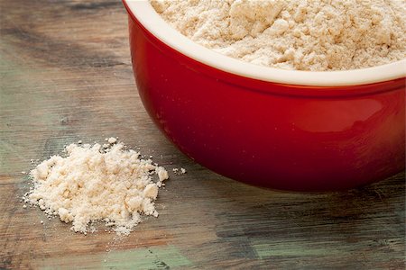 simsearch:400-07300783,k - gluten free coconut flour in a red stoneware bowl and spilled on a wooden cutting board Stockbilder - Microstock & Abonnement, Bildnummer: 400-07300785