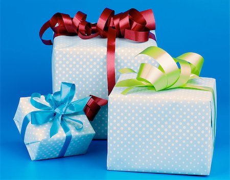 Arrangement of Three Gift Boxes with Ribbons and Bows isolated on Blue background Stock Photo - Budget Royalty-Free & Subscription, Code: 400-07301641
