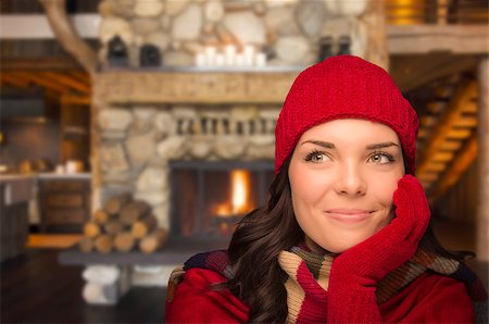 simsearch:400-06462603,k - Smiling, Comfortable Mixed Race Girl Looking To The Side Enjoying Warm Fireplace In Rustic Cabin. Stock Photo - Budget Royalty-Free & Subscription, Code: 400-07303424