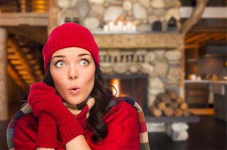 simsearch:400-06462603,k - Smiling, Comfortable Mixed Race Girl Looking To The Side Enjoying Warm Fireplace In Rustic Cabin. Stock Photo - Budget Royalty-Free & Subscription, Code: 400-07303429
