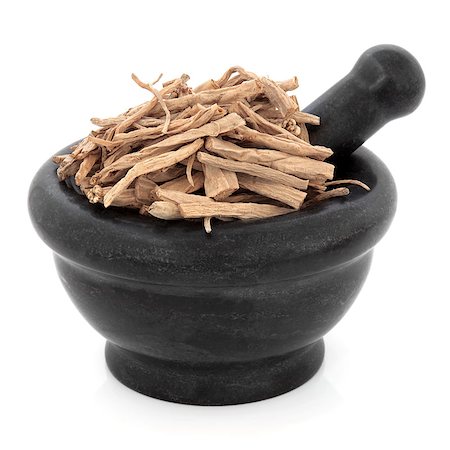 simsearch:400-07174356,k - Stellaria root chinese herbal medicine in a black stone mortar with pestle over white background. Yin chai hu Stock Photo - Budget Royalty-Free & Subscription, Code: 400-07303454