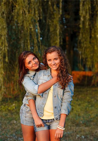 simsearch:400-07303759,k - two teenage girls outdoors in jeans wear hugging looking at camera Stockbilder - Microstock & Abonnement, Bildnummer: 400-07303694