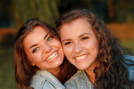 simsearch:400-07303759,k - close-up portrait of two happy teenage girls outdoors in jeans wear smiling looking away Stockbilder - Microstock & Abonnement, Bildnummer: 400-07303695