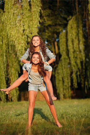 simsearch:400-07303759,k - teenage girl giving her girlfriend piggyback ride in park Stockbilder - Microstock & Abonnement, Bildnummer: 400-07303713