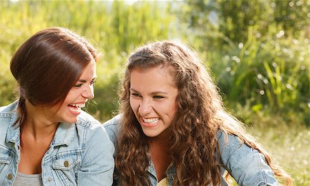 simsearch:400-07303759,k - two girlfriends in jeans wear outdoors sitting  laughing Stockbilder - Microstock & Abonnement, Bildnummer: 400-07303755