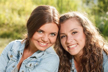 simsearch:400-07303759,k - close-up portrait of two girlfriends in jeans wear outdoors sitting  smiling looking at camera Stockbilder - Microstock & Abonnement, Bildnummer: 400-07303756