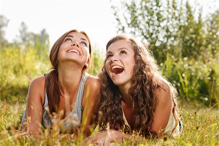 simsearch:400-05372366,k - two girlfriends in T-shirts  lying down on grass having good time looking up Photographie de stock - Aubaine LD & Abonnement, Code: 400-07303762