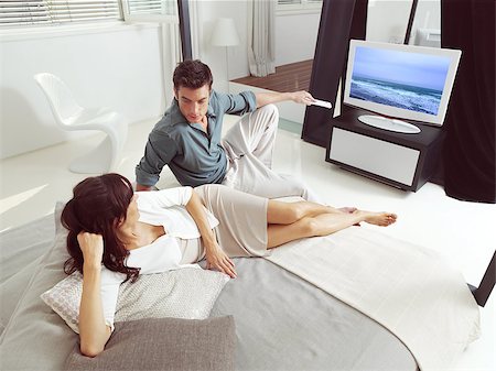 Portrait of happy couple sitting on sofa and watching television together Foto de stock - Super Valor sin royalties y Suscripción, Código: 400-07303834