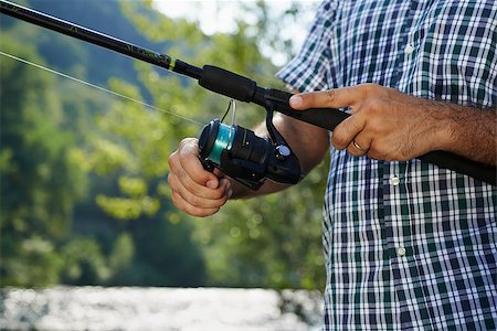 simsearch:400-06852239,k - closeup of fisher on river with hands on reel, relaxing and fishing trout Photographie de stock - Aubaine LD & Abonnement, Code: 400-07303890