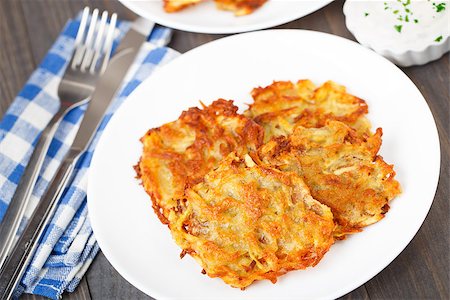 sour cream with baked potatoes - Delicious potato pancakes on a white plate Stock Photo - Budget Royalty-Free & Subscription, Code: 400-07314486