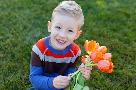 simsearch:400-06768635,k - smiling positive boy holding flowers at spring time Foto de stock - Royalty-Free Super Valor e Assinatura, Número: 400-07316875