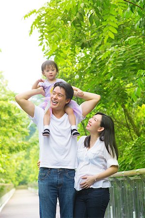 family healthy candid - Happy Asian family outdoor. Father piggyback his daughter walking in garden park with pregnant wife. Healthy lifestyle. Stock Photo - Budget Royalty-Free & Subscription, Code: 400-07318213