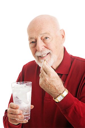 Portrait of a healthy senior man taking omega 3 fish oil with a glass of ice water.  White background. Stock Photo - Budget Royalty-Free & Subscription, Code: 400-07318707