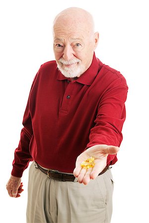 Senior man holding out a handful of omega 3 fish oil capsules.  Isolated on white. Stock Photo - Budget Royalty-Free & Subscription, Code: 400-07318708