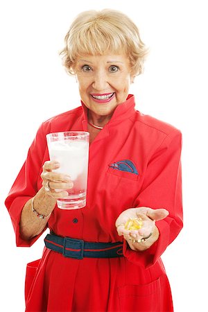 Healthy senior woman taking omega 3 fish oil supplements with a glass of ice water.  Isolated on white. Stock Photo - Budget Royalty-Free & Subscription, Code: 400-07318700
