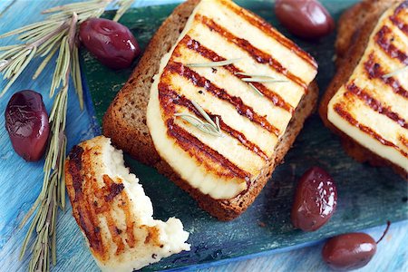 simsearch:400-07260354,k - Grilled cheese, olives, rosemary on blue table. Stockbilder - Microstock & Abonnement, Bildnummer: 400-07326048