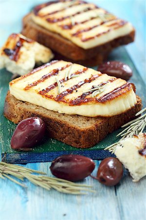 simsearch:400-07260354,k - Grilled cheese, olives, rosemary on blue table. Stockbilder - Microstock & Abonnement, Bildnummer: 400-07326049