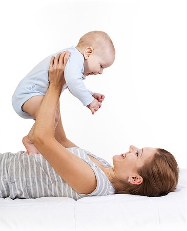 Happy young woman holding baby son while lying on back Stock Photo - Budget Royalty-Free & Subscription, Code: 400-07326145