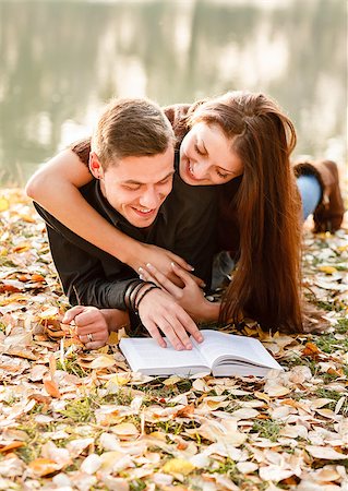 young couple lying down near lake reading book Stock Photo - Budget Royalty-Free & Subscription, Code: 400-07327359