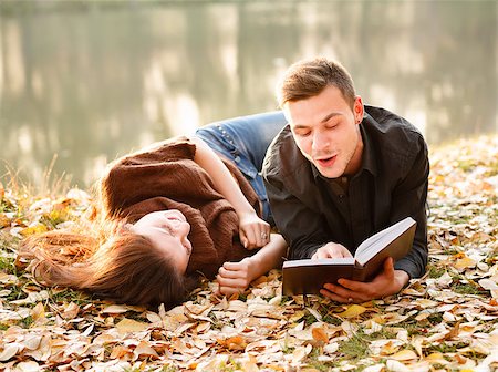 young man lying down near lake reading to his girlfriend Stock Photo - Budget Royalty-Free & Subscription, Code: 400-07327362