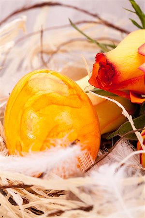 simsearch:400-07921731,k - Vivid orange Easter egg with a painted marble pattern nestling in a straw nest with a fresh gerbera daisy and rose to celebrate Easter and spring Stock Photo - Budget Royalty-Free & Subscription, Code: 400-07328459