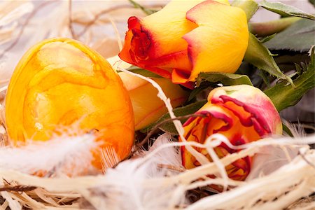 simsearch:400-07921731,k - Vivid orange Easter egg with a painted marble pattern nestling in a straw nest with a fresh gerbera daisy and rose to celebrate Easter and spring Stock Photo - Budget Royalty-Free & Subscription, Code: 400-07328460