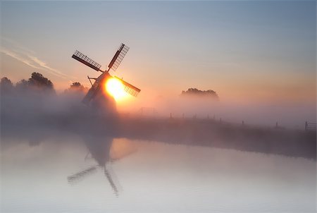 simsearch:400-04968925,k - sun behind windmill and fog at summer sunrise, Holland Photographie de stock - Aubaine LD & Abonnement, Code: 400-07329825