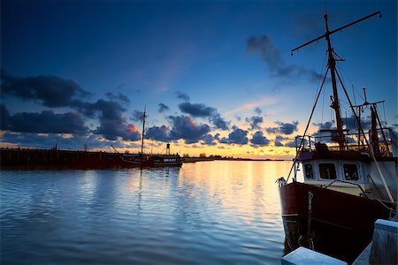 simsearch:400-08432432,k - Dutch fishing boats on river at sunset, Zoutkamp, Netherlands Fotografie stock - Microstock e Abbonamento, Codice: 400-07329834