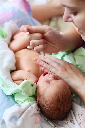 simsearch:400-08932328,k - Mother feeding newborn baby milk with syringe Stock Photo - Budget Royalty-Free & Subscription, Code: 400-07320908